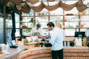 barista talking with customer about tasted of coffee cup with happy emotion at counter bar at...