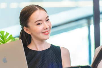 Smart young businesswoman is working on a project in a startup company modern office. Concept of professional employees collaboration, teamwork and brainstorming. Atmosphere of workplace or cyberspace