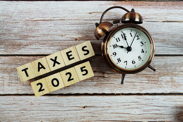 Taxes 2025 alphabet letter on wooden background