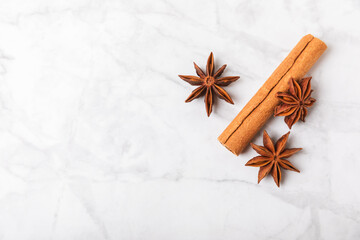 Obraz na płótnie Canvas Cinnamon sticks and anise on a textured background. Cinnamon roll and star anise. Spicy spice for baking, desserts and drinks. Fragrant ground cinnamon.Place for text. copy space.