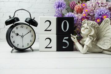 Happy New Year 2025 with wood block number on wooden table background decorations with alarm clock...