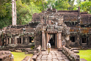 Female tourist walking to ancient Angkor temple in Cambodia - 787257502