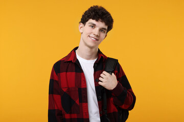 Portrait of student with backpack on orange background