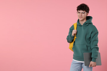 Portrait of student with backpack and laptop on pink background. Space for text