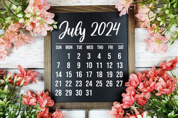 July 2024 monthly calendar with flower bouquet decoration on wooden background