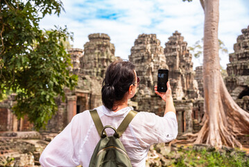 Female tourist taking photo of ancient Angkor temple in Cambodia - 787258919