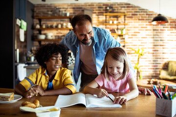 Father helping children with homework at kitchen table - obrazy, fototapety, plakaty