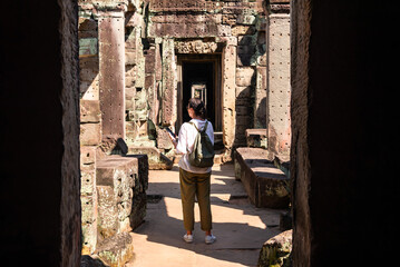 Female tourist looking at ancient Angkor temple in Cambodia - 787259519