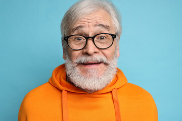 Senior man with mustache on light blue background