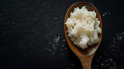 Uncooked rice with a wooden spoon Raw surti kolam rice over black background copy space :...