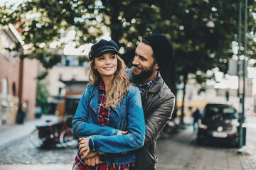Stylish young couple walking and smiling on a city street
