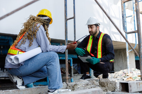 Construction civil engineer man and woman African American checking quality water pipes inside and drainage system building of work in construction site.