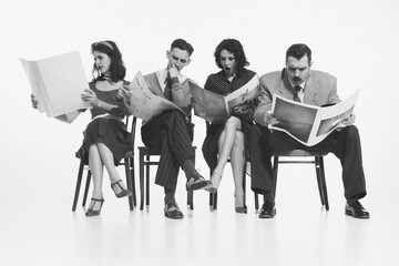 Group of four people, men and women in retro-style clothes sitting on chair and reading newspapers,...