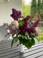 Blumenstrauß mit Flieder auf dem Tisch auf dem Balkon