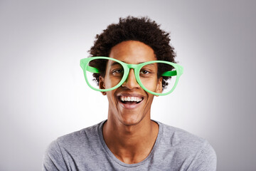 Funny, big glasses and black man with a smile, happy and funky eyewear on a white studio...