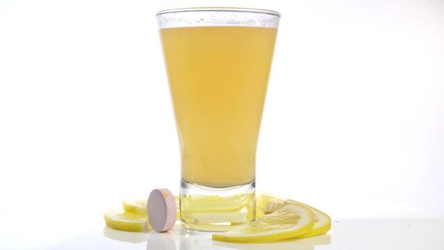 Vitamin C effervescent drink with tablet and pieces of lemon fruit