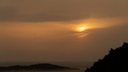 Fototapeta premium Sunset behind some clouds over the ocean