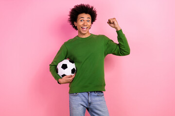Photo of happy positive guy sport fan hold soccer ball raise fists up winning isolated pastel color...