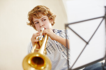 Playing, music and child with notes and trumpet for practice, jazz lesson and learning for talent...