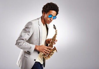 Saxophone, black man and sunglasses with jazz artist, creative and expression on grey studio...