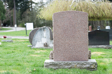 A large blank tombstone in cemetery.