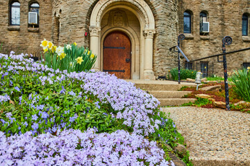 Fototapeta na wymiar Spring Blossoms at Historic Stone Church, Ground-Level View