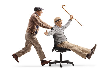 Elderly man pushing a friend seated in an office chair on wheels