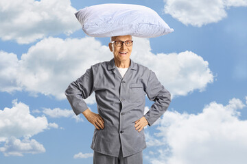 Elderly man in pajamas with pillow on his head