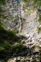Brinta Waterfall hidden inside the forest, beauties of Slovenia to be discovered. Near Nova Gorica, Tolmin village. Water spray, vivid rainbow forms from the waterfall that falls sheer onto the rock.