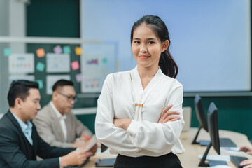 Happy confident smiling young professional Asian business woman corporate leader, Japanese female employee or company sales marketing manager standing arms crossed in office, cute girl portrait