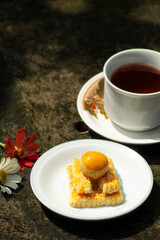 cheese cake with tea and flowers beside