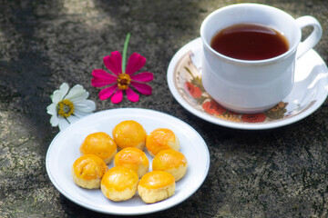 cheese cake with tea and flowers beside