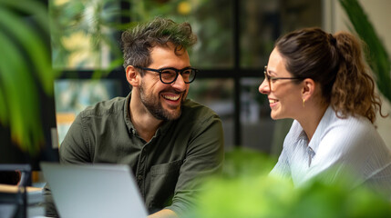 Cheerful Colleagues Sharing a Laugh in a Green Office Environment