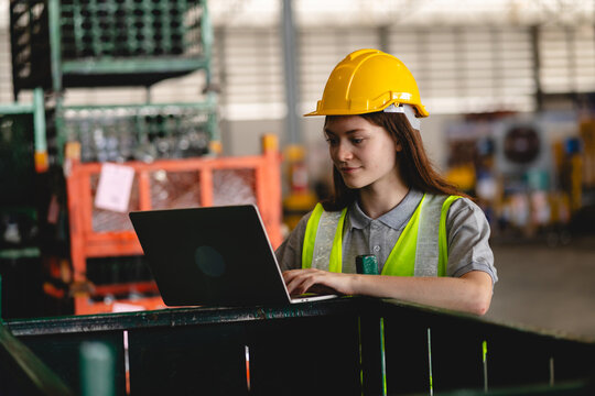 Female engineer using laptop computer for safety control checks or manufacturing maintenance work in factory building or construction site. woman engineer inspector working in industry product line - Powered by Adobe