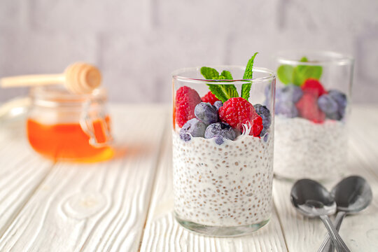 Healthy vanilla chia pudding in a glass with fresh berries and honey