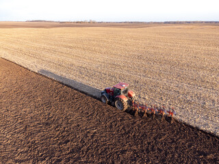 Aerial shot of tractor, ploughing field, made with drone. Farming, cultivating the land, machinery concepts
