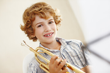 Smile, music and portrait of child with trumpet for learning, orchestra lesson and practice for...