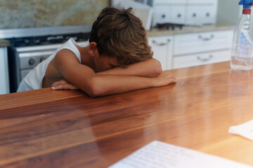 Child, head and table for sad in home for emotional youth as tween for mistake, trouble or tired....