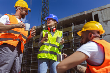 Three constructions workers having coffee and lunch break at construction site. - 787319181