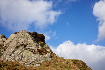 A rocky outcrop against a  blue sky with white clouds at Craignish Point. Ardfern, Argyll and Bute, Scotland
