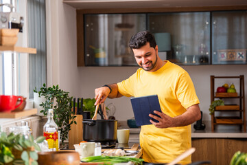 Indian asian man in kitchen cooking alone and having fun.