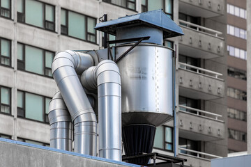 an aluminum restaurant kitchen exhaust vent grease trap against backdrop of high rise residential...