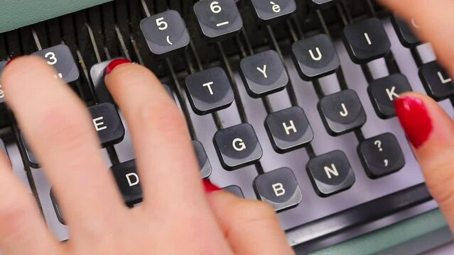 fingers with nail polish of young secretary typing the keys on the keyboard in the office