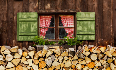 Fenster mit Grünen Fensterläden und karierter Gardine auf einer Almhütte