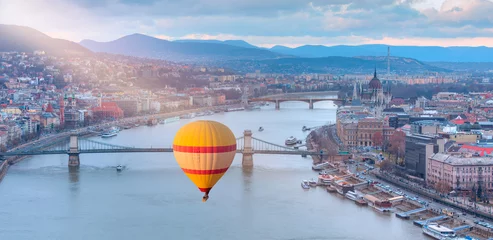 Foto op Plexiglas Kettingbrug Hot air balloon flying over Hungarian parliament and Chain Bridge at sunset in Budapest 