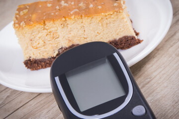 Glucometer for measuring sugar level and sweet cheesecake. Nutrition during diabetes