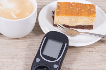 Glucose meter, piece of sweet cheesecake and cup of coffee with milk. Checking sugar level during diabetes
