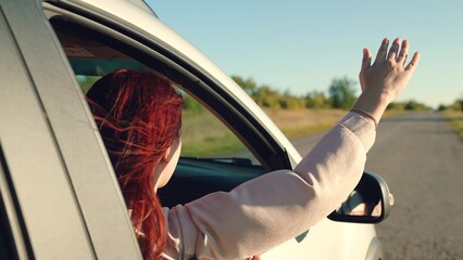 girl rides car with her hand out window, beautiful young woman smiling sunset, hand moving wind, happy family, cheerful girl looking out open car window, people travel, adventure lifestyle, curly hair - obrazy, fototapety, plakaty