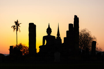 Sukhothai Historical Park. Thailand. Buddha silhouette and and ancient buddhist temple ruins at...