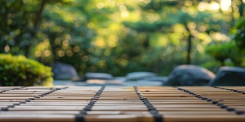 A tranquil image focusing on bamboo mats with a soft blurry background of a lush green garden bathed in sunlight - obrazy, fototapety, plakaty